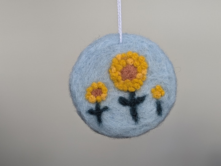 A round sky blue decoration with stylized flowers.