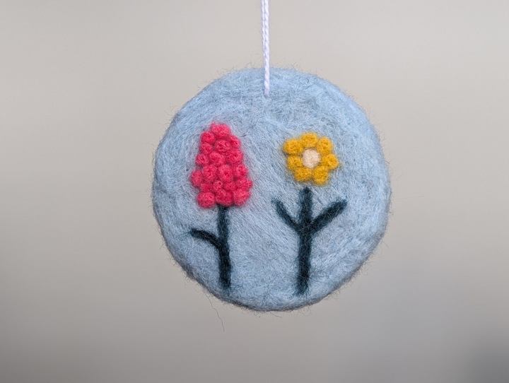A round sky blue decoration with stylized flowers.