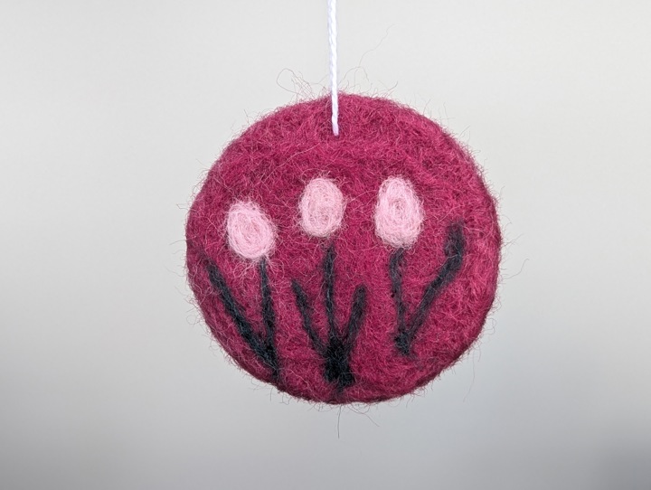 A round burgundy decoration with stylized flowers.