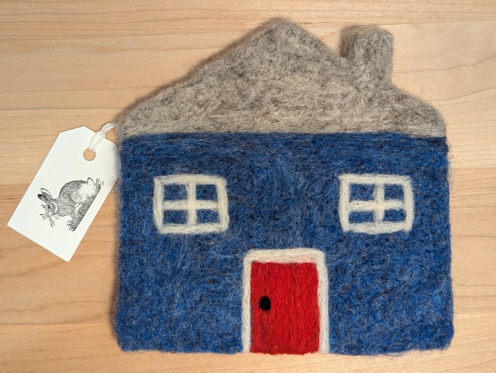 A felted heather blue house with a heather grey roof and a red door.