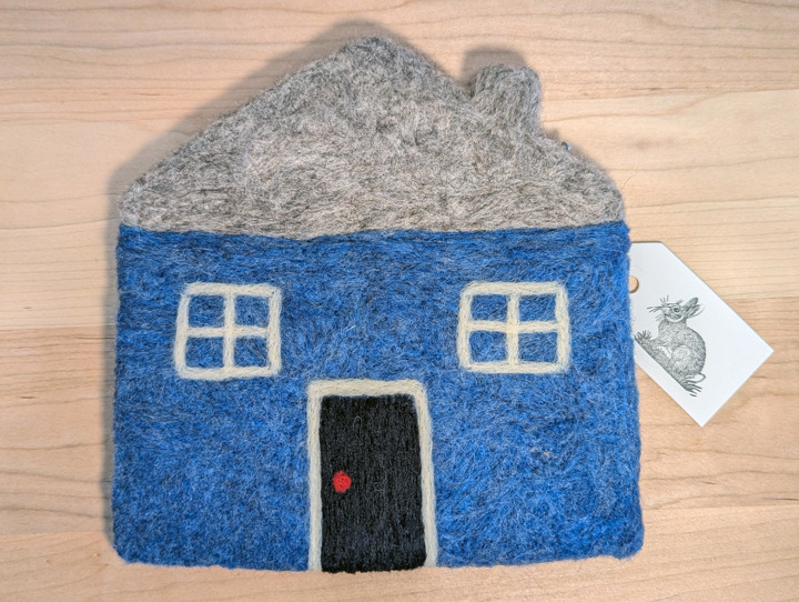 A felted blue house with a heather grey roof and a black door.