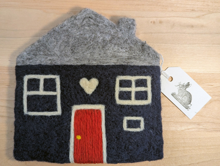A felted navy blue house with a heather grey roof and a red door with a white heart motif above it.