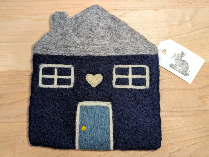 A felted navy blue house with a heather grey roof and a country blue door with a white heart motif above it.
