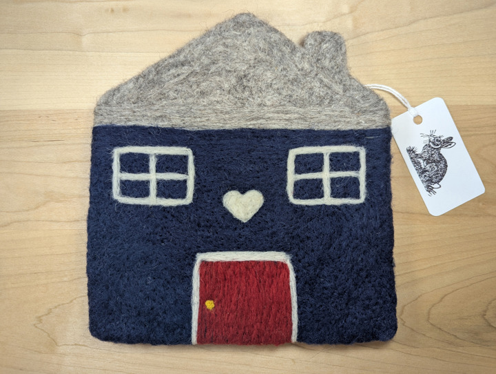 A felted navy blue house with a heather grey roof and a red door with a white heart motif above it.