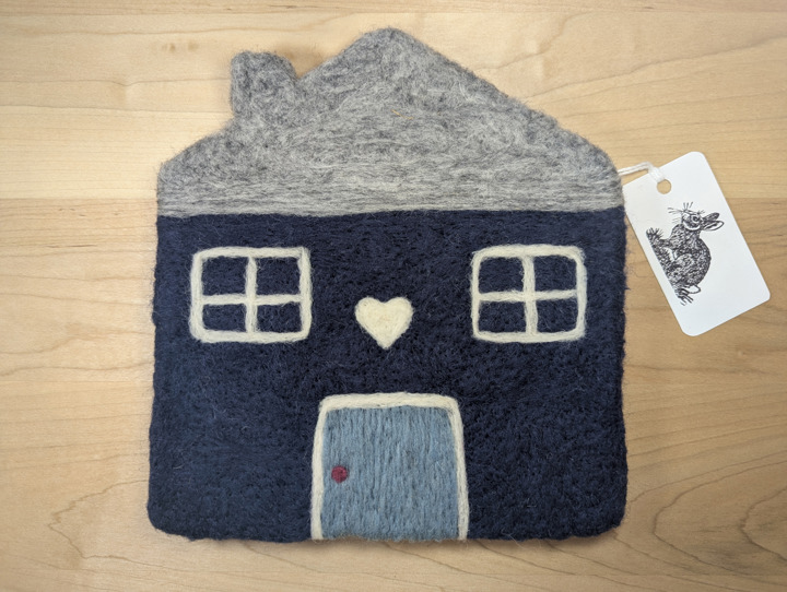 A felted navy blue house with a heather grey roof and a country blue door with a white heart motif above it.