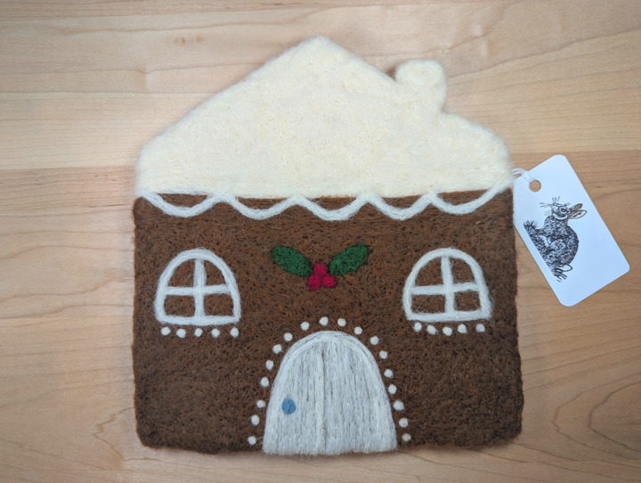 A felted gingerbread house with lashings of icing and a holly and ivy motif above the door.
