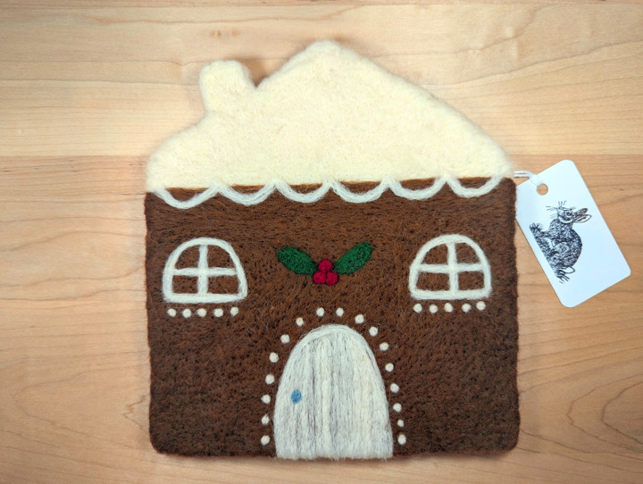 A felted gingerbread house with lashings of icing and a holly and ivy motif above the door.
