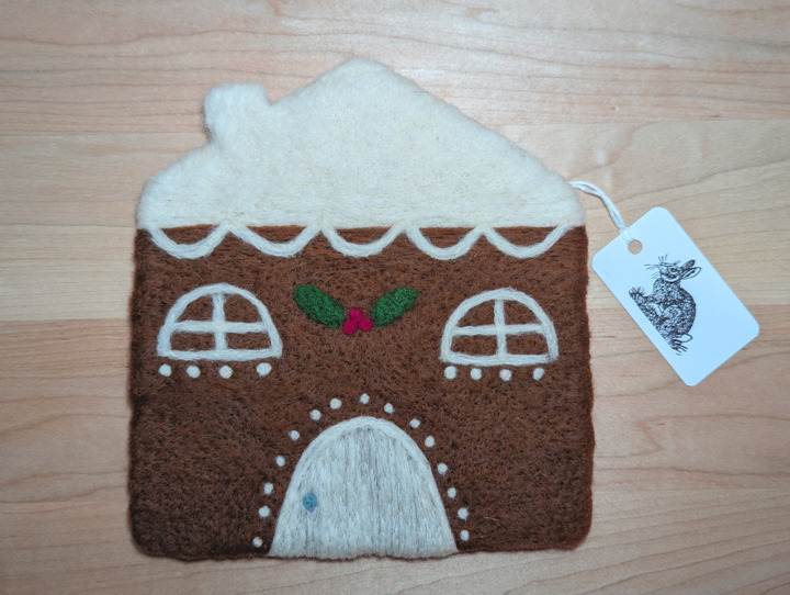 A felted gingerbread house with lashings of icing and a holly and ivy motif above the door.