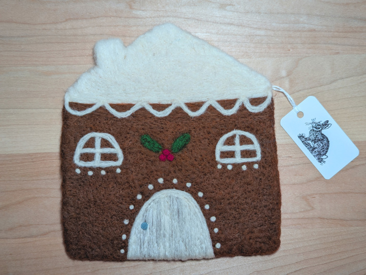 A felted gingerbread house with lashings of icing and a holly and ivy motif above the door.